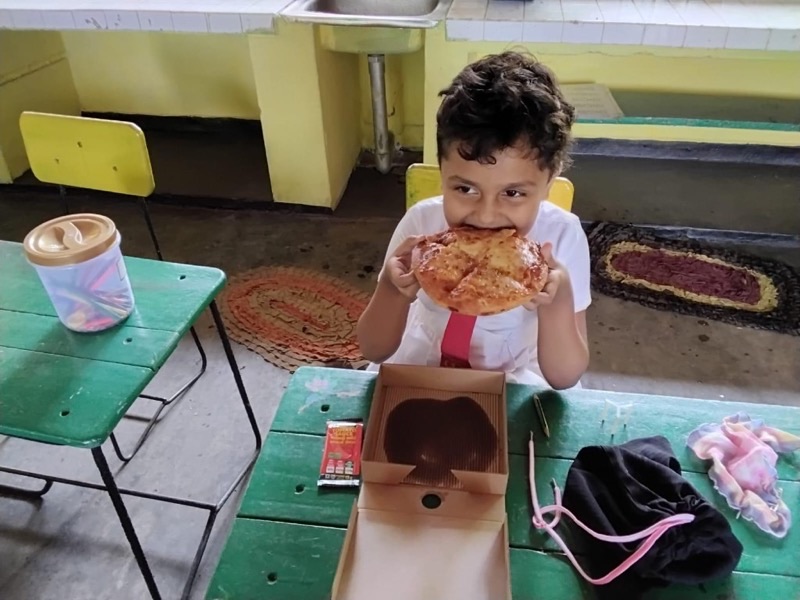 Student enjoying a slice of pizza at school